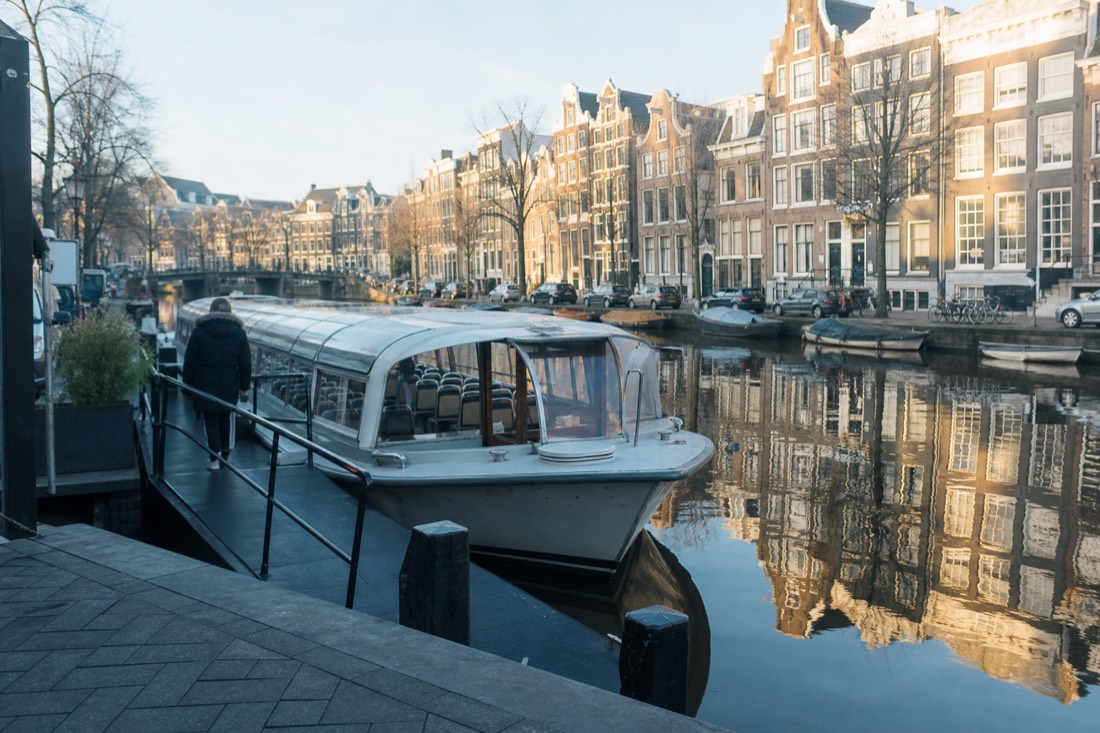 A jetty on the Keizersgracht with a covered cruise boat boarding, no text, no logos, no people.